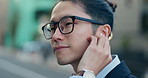 Business man, city and listening to music, digital podcast and streaming audio connection with earphones. Face, Japanese employee and thinking of sound for radio subscription in urban street in Tokyo