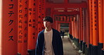 Thinking, walking and man in Torii gate in Kyoto with peace, mindfulness and travel with spiritual history. Architecture, Japanese culture and person in orange tunnel at Shinto shrine in zen mindset.