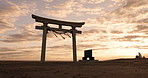 Torii gate, sunset and cloudy sky in Japan with peace, zen and spiritual history on travel adventure. Shinto architecture, Asian culture and calm nature on Japanese landscape with sacred monument.