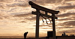 Torii gate, sunset sky in Japan and man in silhouette with clouds, zen and spiritual history on travel adventure. Shinto architecture, Asian night culture and calm nature on Japanese sacred monument.