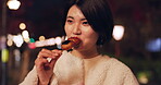 Woman, street food and eating Japanese snack for travel experience, hungry or local trip. Female person, sidewalk and night or bite grilled mochi on road for vacation culture, adventure or tradition