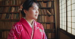 Japanese woman, window and traditional clothes in library with vision, ideas or remember for studying religion. Girl, person and thinking by bookshelf, memory or mindfulness for spiritual development