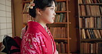 Japanese woman, thinking and traditional clothes in library with vision, ideas or remember for studying religion. Girl, person and memory by bookshelf, desk and mindfulness for spiritual development