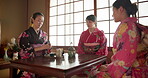 Friends, traditional and Asian women with tea for culture with cup, peace or teapot in home. Benefits, ceremony or people at table with herbal beverage to relax or detox wellness for drinking ritual