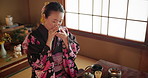 Traditional, teapot and happy Asian woman with tea for culture with herbs, leaves and flavor in home. Ritual, ceremony and person with herbal beverage for relaxing, calm and wellness for drinking