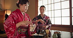 Japanese women, together and tea for culture with friends, respect or kindness to relax with chat at table. Girl, people and date for traditional drink, fashion or indigenous clothes with cup in home