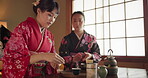 Women, Japanese and tea ceremony for calm tradition in tatami room for healing ritual, harmony or mindfulness. Female people, kimono dress and hot drink for connection, religious experience or health