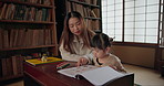 Japanese Mom, girl and learning with homework, reading and books for study, development and helping hand. Education, mother and daughter with notes, talk and check progress in family house with study