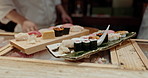 Cooking, hands and sushi chef in a restaurant with catering, fish and Japanese dish in a kitchen. Menu, culinary artist and fine dining with meal, maki and person with tuna and sashimi for dinner