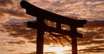 Sunset, torii gate and skies in shrine, holy place and spiritual for worship, gods and religion. Evening, prayer and sacred spot for faith, beliefs and dusk in Japan, traditional and cultural symbol