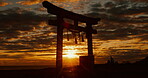 Sunset, torii gate and people in shrine, holy place and spiritual for worship, gods and religion. Evening, prayer and sacred spot for faith, beliefs and dusk in Japan, traditional and cultural symbol