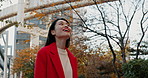 Japanese woman, city and park with walk, location or thinking with smile, excited or freedom in nature. Girl, person and tourist on adventure, ideas or happy for vacation, buildings or trees in Tokyo