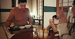 Japanese dad, mom and child at dinner, happy and together for bonding, love or care in night at table. Father, mother and kid with noodles, supper or food with giving, applause or help in family home