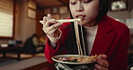 Woman, ramen and eating noodles in restaurant for nutrition, healthy meal and closeup with chopsticks. Person, Japanese cuisine and food for lunch or dinner in cafeteria with enjoyment and hungry