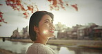 Smile, calm and Japanese woman in the city with cherry blossom for zen, peace and mindfulness. Happy, break and young female person sightseeing in nature of urban town Tokyo with positive attitude.