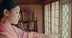 Open, home window and Japanese woman with screen door, Shoji  and morning in a Japan tea house. Geisha, local and calm in a living room with female person and traditional and Shinto dress in lodge
