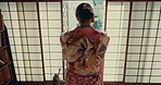 Woman, back and open Japanese window with traditional kimono, fashion or culture. Asian, home and person in morning with sunshine or light on sliding door or lattice architecture in Tokyo house