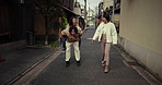 Friends, piggy back and Japanese women in city for bonding, conversation and relax together. Laugh, happy and people chat, walking and travel in Japan for holiday, vacation and adventure in street