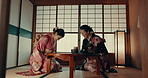 Japanese, tea and traditional women bow in ceremony with service of matcha or ginseng with hospitality. Ancient, culture and friends talking in kimono with respect for indigenous heritage or beverage