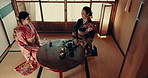 Women in traditional Japanese room with tea ceremony, kimono and relax together with mindfulness. Friends visit at calm teahouse with matcha drink, zen culture and connection at table for wellness.