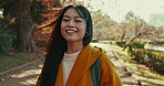 Japanese woman, face and smile in park for travel, vacation or adventure with backpack, path and trees. Gen z person, girl and happy in portrait for holiday, walking and nature by forest in Kyoto