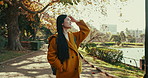 Outdoor, thinking and Japanese woman with sunshine, park and journey with vacation, daydreaming and wonder. View, outside and person with nature, relax or freedom with wellness, holiday and adventure