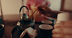 Culture, teapot and hands of Asian woman with tea with traditional leaves and indigenous herbs. Health, home and people with herbal beverage for relaxing, wellness and detox for drinking ritual