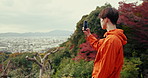 Man, phone and photography for landscape on hiking adventure by trees, woods and thinking with post on blog. Japanese person, smartphone and photoshoot of cityscape, nature and social media in Kyoto