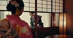 Women in traditional Japanese tea house, kimono and relax with mindfulness, respect and service. Woman at calm tearoom with drink on tray, zen culture and connection sitting at table for wellness.