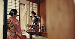 Women in traditional Japanese house with tea, kimono and relax together with mindfulness. Friends visit at calm tearoom with matcha drink, zen culture and connection sitting at table for wellness.