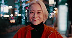Woman, face and city lights or street at night to explore Japan, vacation adventure or downtown evening. Female person, smile and international travel in town or weekend for outdoor, relax or holiday
