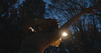 Woman, dancer and night in forest, trees and moving body for fantasy, nature and freedom in performance. Person, girl and artist with dancing, steps and outdoor in dark woods, environment or park