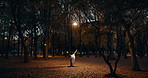 Woman, dancer and ballerina in trees, night and moving body for fantasy, nature and freedom in performance. Person, girl and ballet with dancing, steps and outdoor in dark woods, autumn and forest