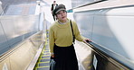 Airport, travel and asian woman tourist on escalator in terminal for trip, journey or international adventure. Destination, holiday or vacation with young passenger boarding a flight for departure
