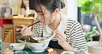 Japanese woman in restaurant, eating ramen and food for lunch or dinner. Noodles, bowl and a young hungry person, customer or girl with chopsticks to enjoy healthy meal or  traditional cuisine alone