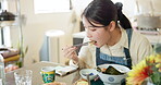 Japanese woman in restaurant, eating gyoza and food for lunch at dinner table. Chopsticks, dumpling and a young hungry person, customer or girl enjoying a healthy meal or traditional cuisine in bowl