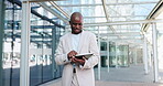 Black man, tablet and commute to work, city and typing online, digital and technology. Working, cape town and busy in urban area, office buildings and businessman for networking and checking email
