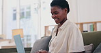 African woman, laptop and sofa for remote work from home with smile, typing and social media management. Person, freelance worker and computer with ideas, content creation and writing for web blog