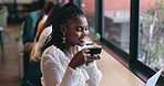 Coffee shop, relax and black woman by window with drink for happiness, calm and breakfast in cafe. Restaurant, weekend and happy person with mug, aroma and scent for latte, caffeine and cappuccino