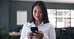 Phone, networking and business woman in the office browsing on social media or the internet. Smile, research and professional Asian female person scroll on mobile app with cellphone in workplace.