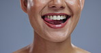 Teeth, mouth and tongue out, woman with beauty or dental, happy for dermatology and orthodontics on grey background. Lick, smile and zoom for oral health, hygiene and wellness with grooming in studio