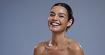 Skincare, wellness and face of woman on blue background laugh with confidence, beauty and cosmetics. Dermatology, aesthetic and portrait of happy person with natural glow and healthy skin in studio