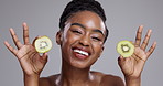 Skincare, kiwi and face of happy black woman on gray background for spa wellness, beauty or cosmetics. Dermatology, studio and portrait of person with fruit for nutrition, organic or natural benefits