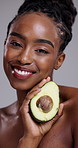 Beauty, avocado and face of happy woman in studio for healthy cosmetics, nutrition or diet on grey background. Portrait, african model or fruit for sustainable dermatology, eco benefits or skincare
