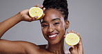 Lemon, beauty and face of woman in studio for vitamin c benefits, nutrition or glow on grey background. Portrait, happy african model or citrus fruits for eco skincare, sustainable cosmetics and diet