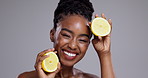 Lemon, beauty and face of woman laugh in studio for vitamin c benefits, nutrition or glow on grey background. Portrait, african model or citrus fruits for eco cosmetics, sustainable skincare and diet