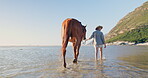 Woman, travel and horse relaxing on beach, nature and peaceful vacation or holiday by ocean. Female person, animal and back view while walking on shore, calm and sea adventure on coast and carefree