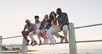 Beach, happy and friends relax in city for bonding, adventure and social gathering outdoors. Friendship, fashion and group of men and women by ocean for travel on holiday, vacation and weekend