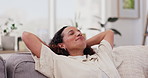 Woman, breathe and comfortable at home on weekend, smile and eyes closed for relaxing on couch. Female person, resting and daydreaming on vacation, calm and peaceful in living room and mindfulness