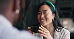 Happy asian woman, friends and coffee at cafe for conversation, catch up or break together. Young female person talking to man with smile or cup of tea for friendly discussion at indoor restaurant